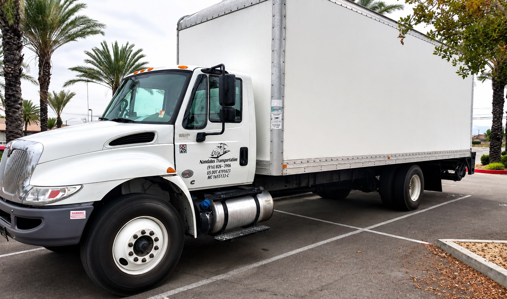 Nmotions 26 foot white box truck parked, ready for a load